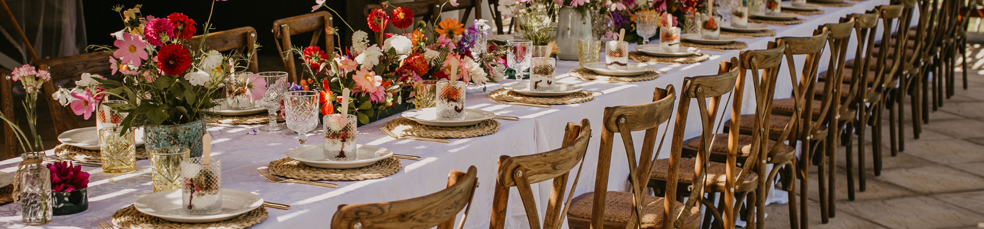 Table set with flowers and beautiful glasses and dishes for a fancy party.