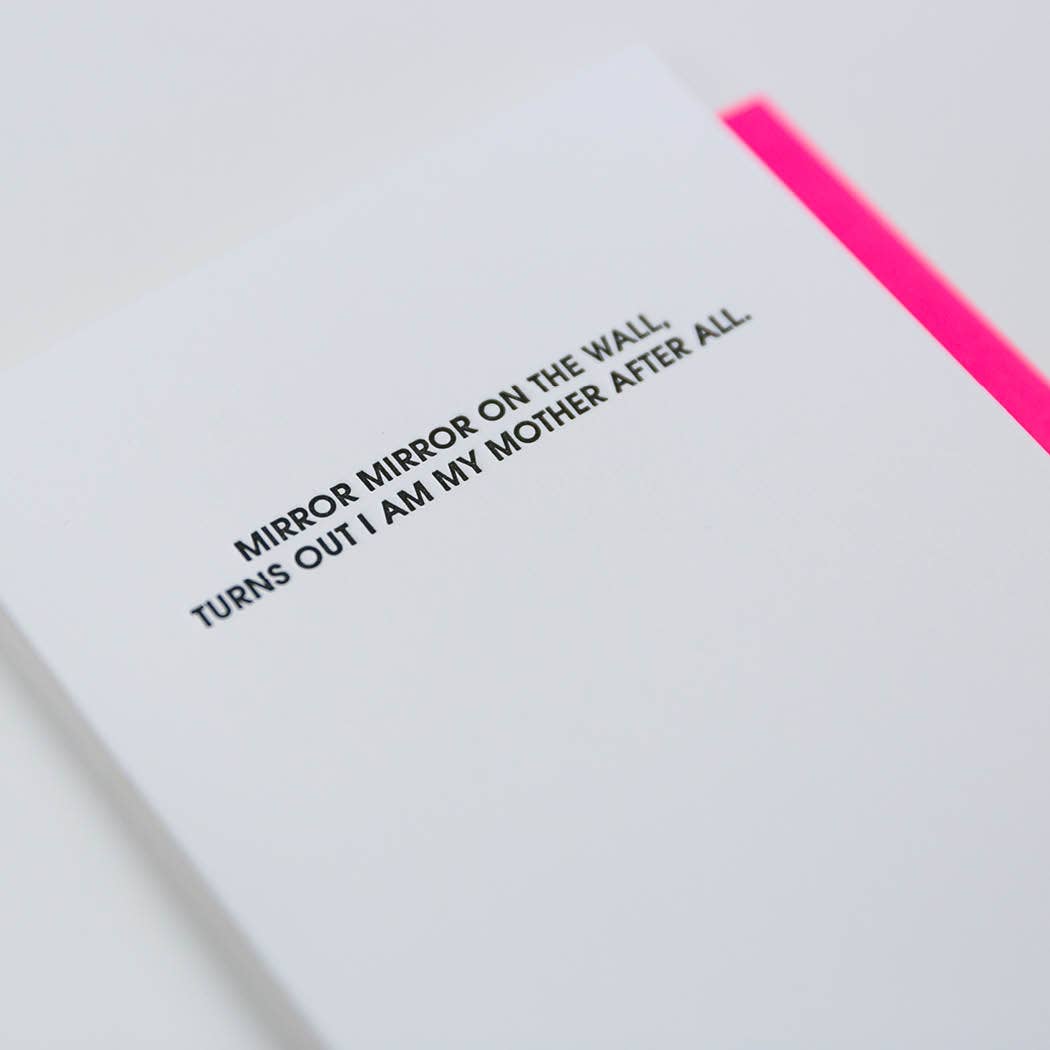 White card with "Mirror mirror on the wall, turns out I am my mother after all." in black lettering. Neon pink envelope.