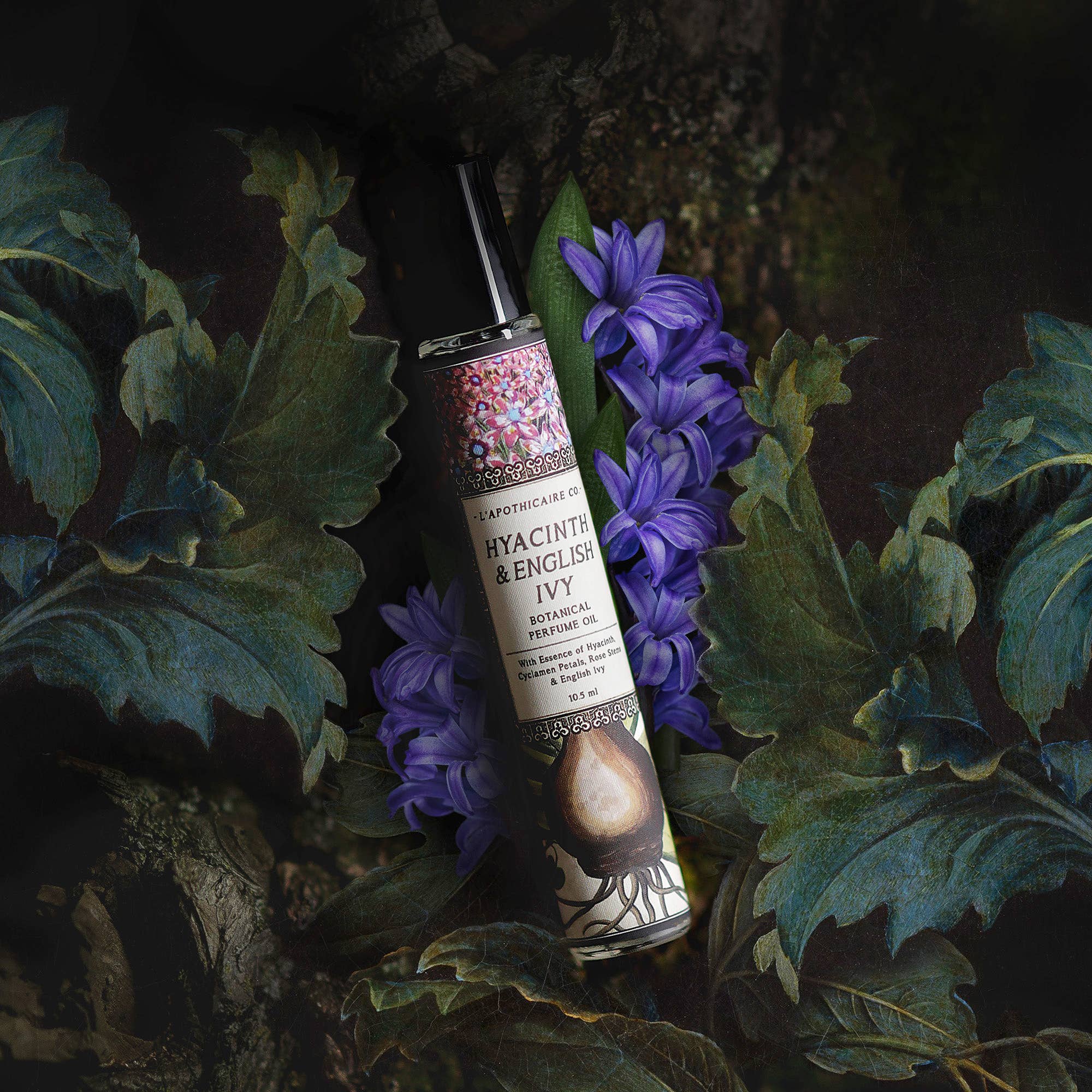 Perfume in glass tube with black lid.  Label states "Hyacinth and English Ivy perfume oil" Hyacinth flowers and bulb are illustrated on label.