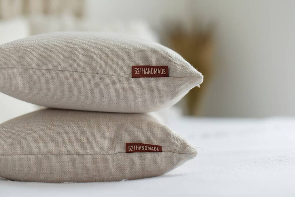 Two linen pillows stacked with red 521 Handmade label