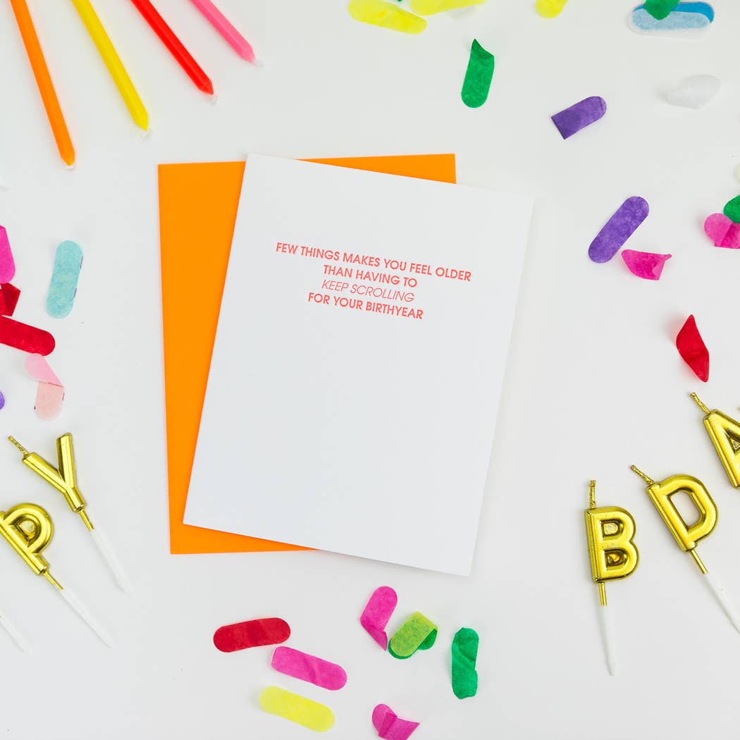 White card with "Few things makes you feel older than having to keep scrolling for your birthyear" in neon red lettering.  Neon orange envelope.