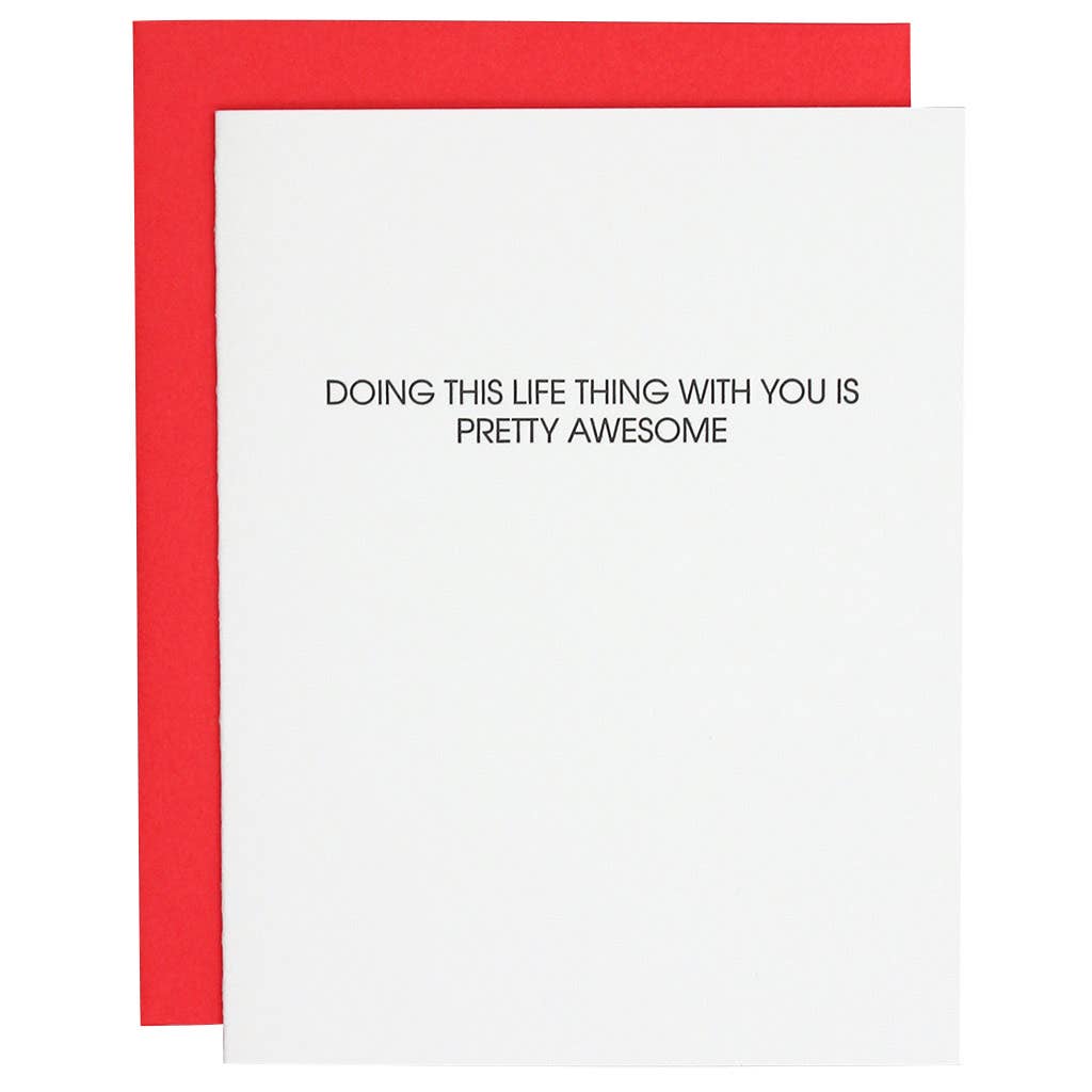 White card with "Doing this life thing with you is pretty awesome" in black lettering. Neon red envelope.