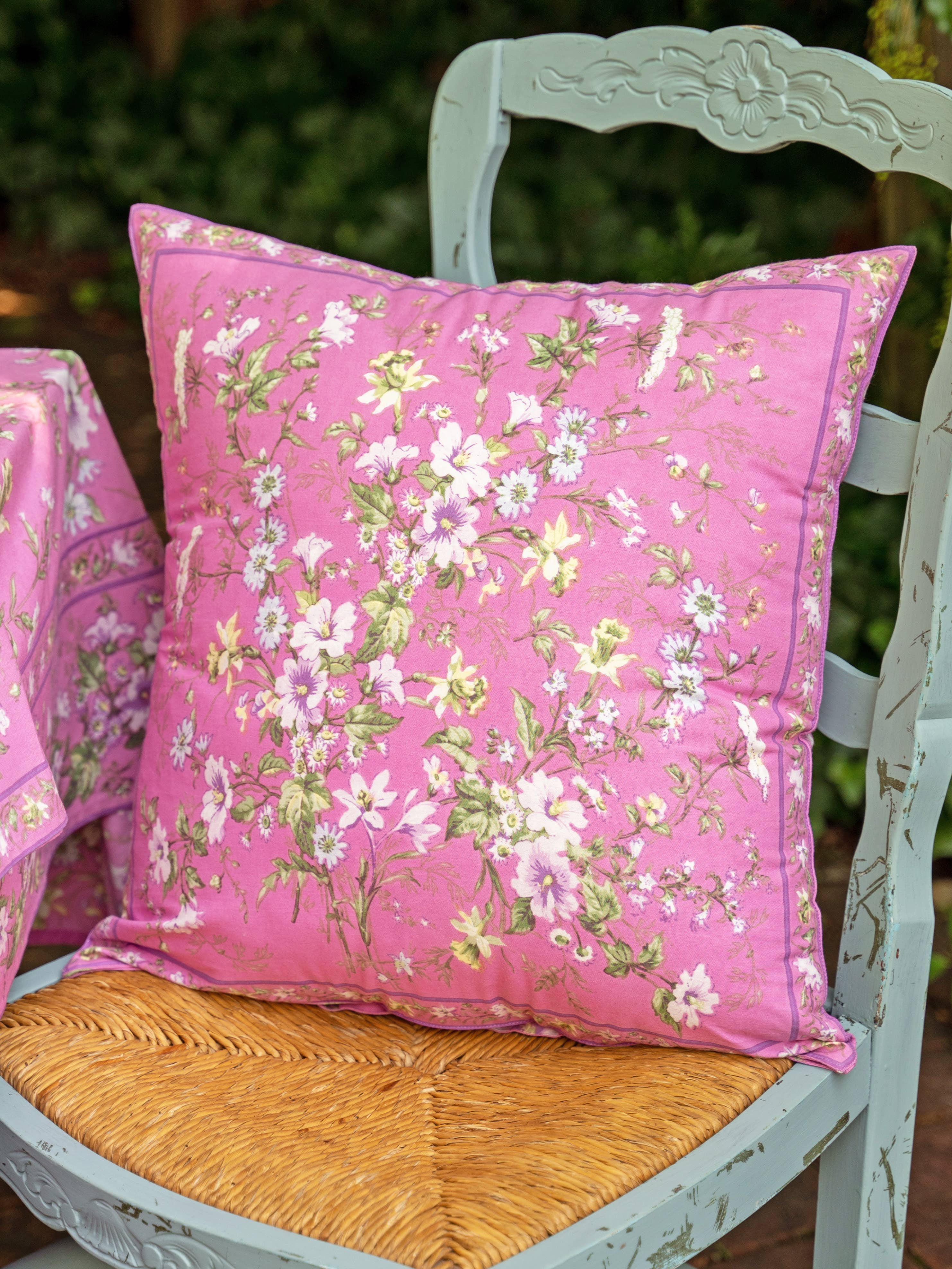 Pillow with cotton fabric, pink background with white and pink flowers and green foliage.