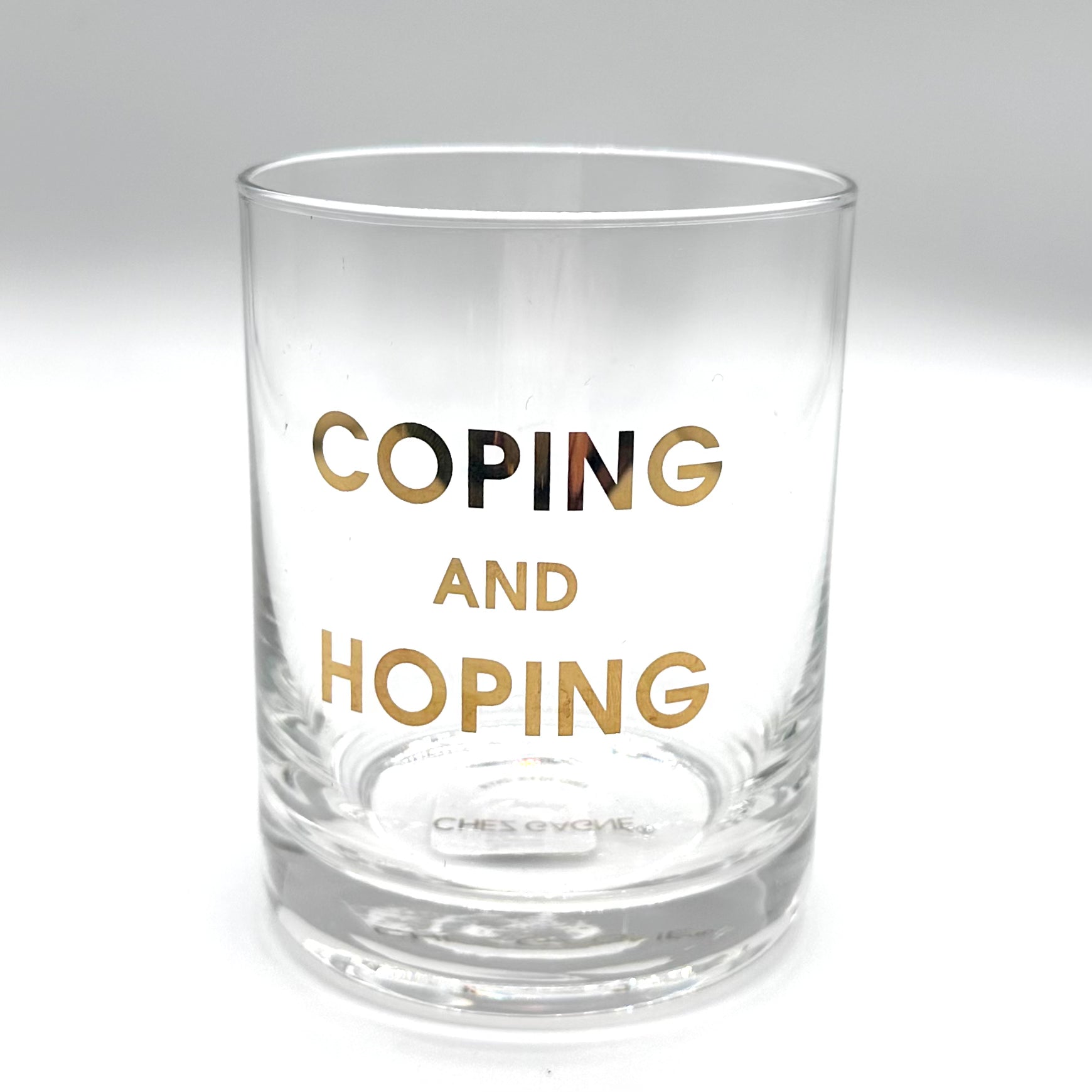 Clear rocks glass with "COPING AND HOPING" in gold lettering