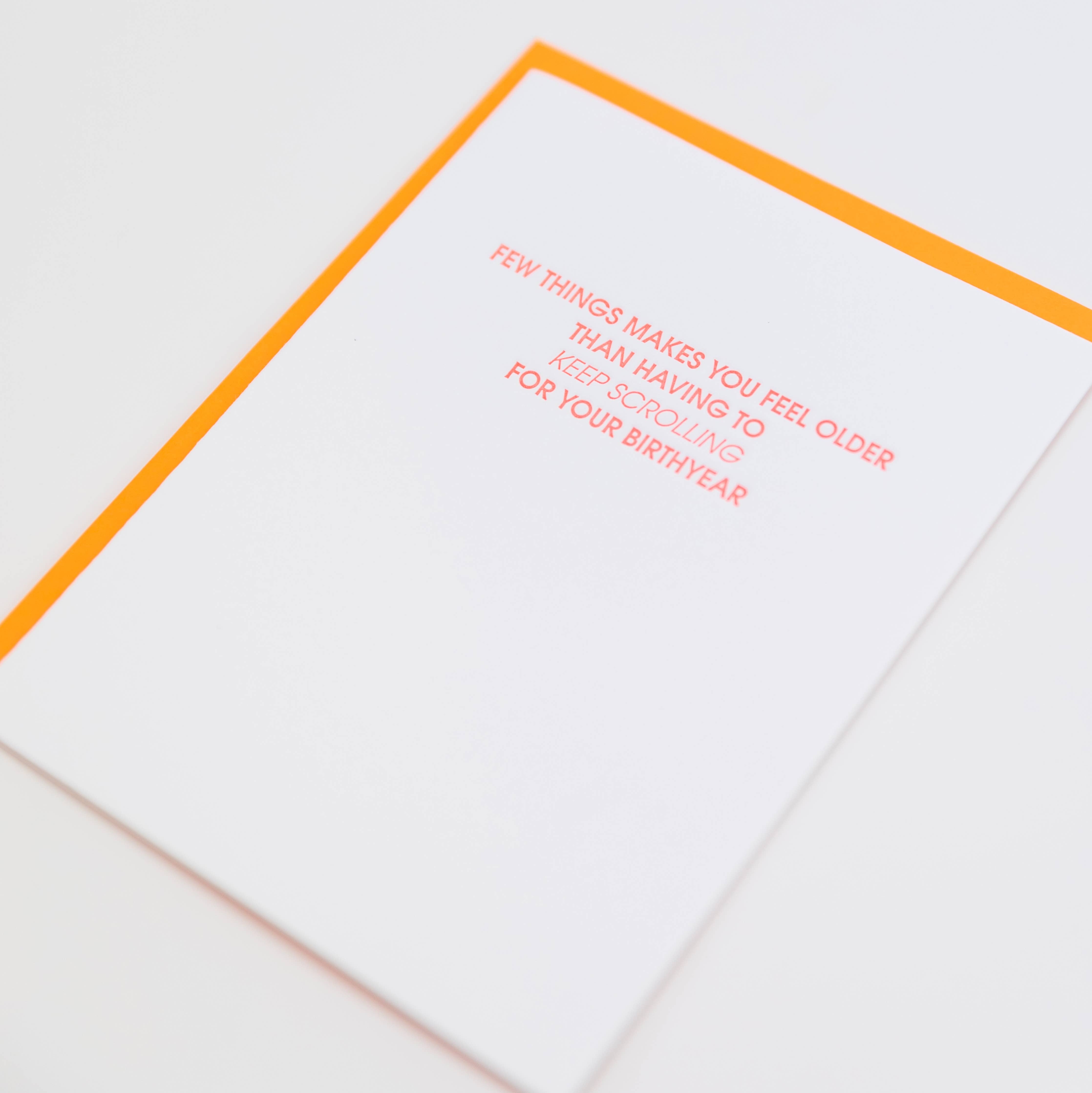 White card with "Few things makes you feel older than having to keep scrolling for your birthyear" in neon red lettering.  Neon orange envelope.