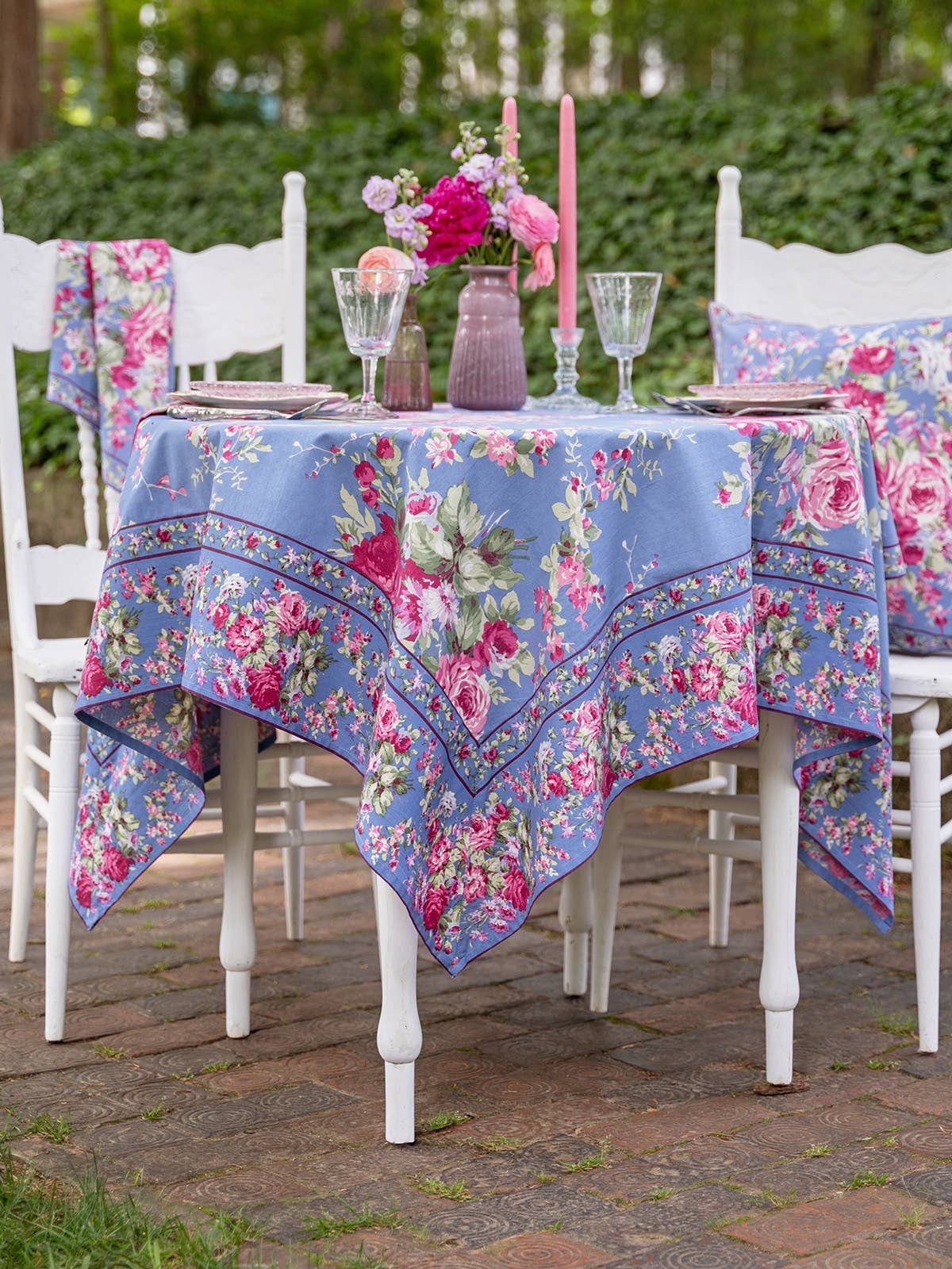 Cotton tablecloth with blue background bright pink floral pattern with green foliage. 