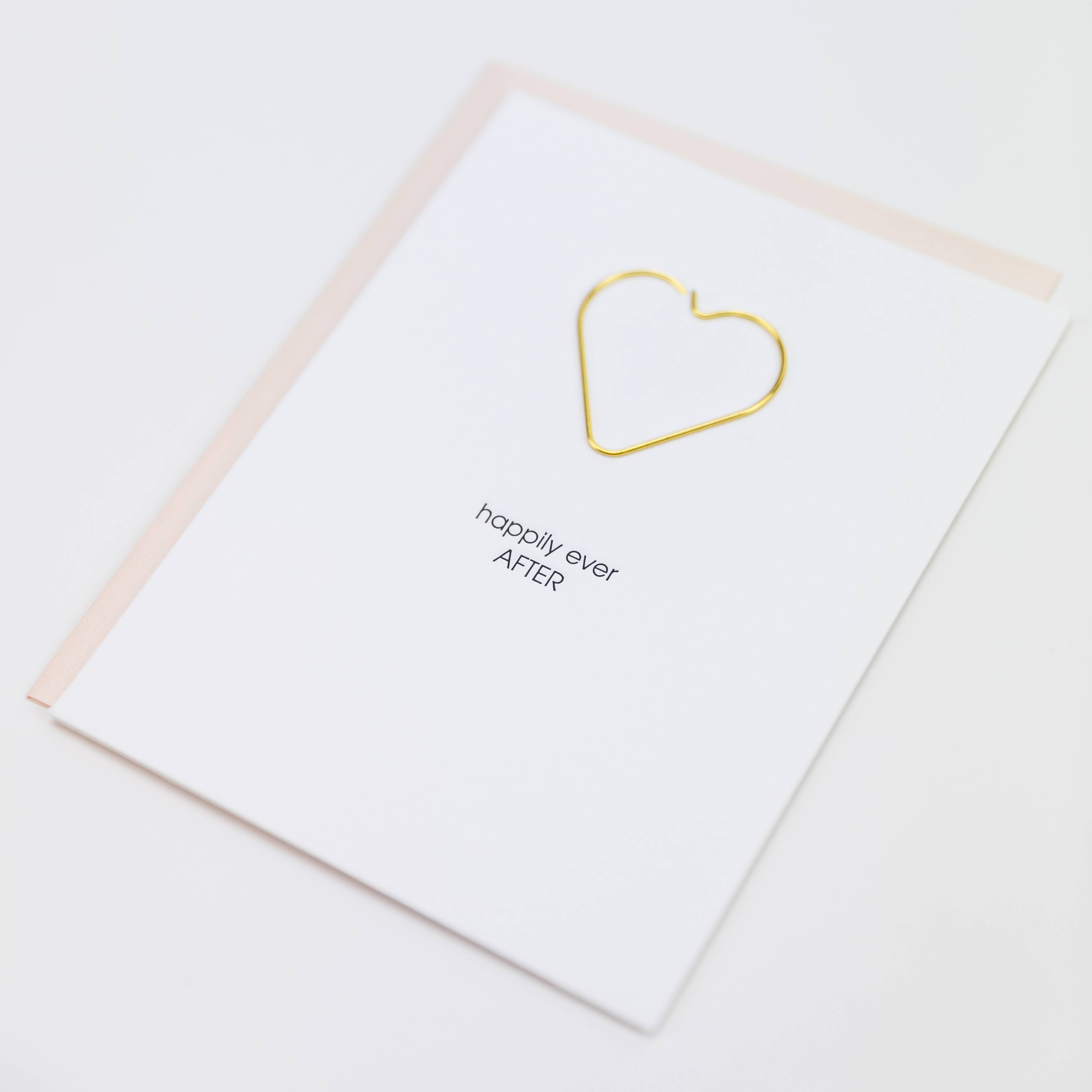 White card with gold heart shaped paperclip included and "happily ever after" in black lettering. Pearl pink envelope.