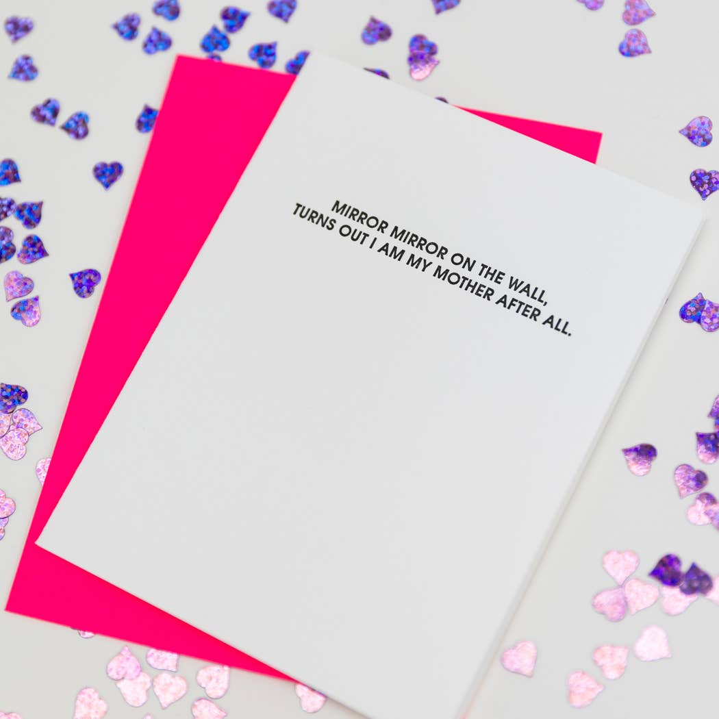 White card with "Mirror mirror on the wall, turns out I am my mother after all." in black lettering. Neon pink envelope.