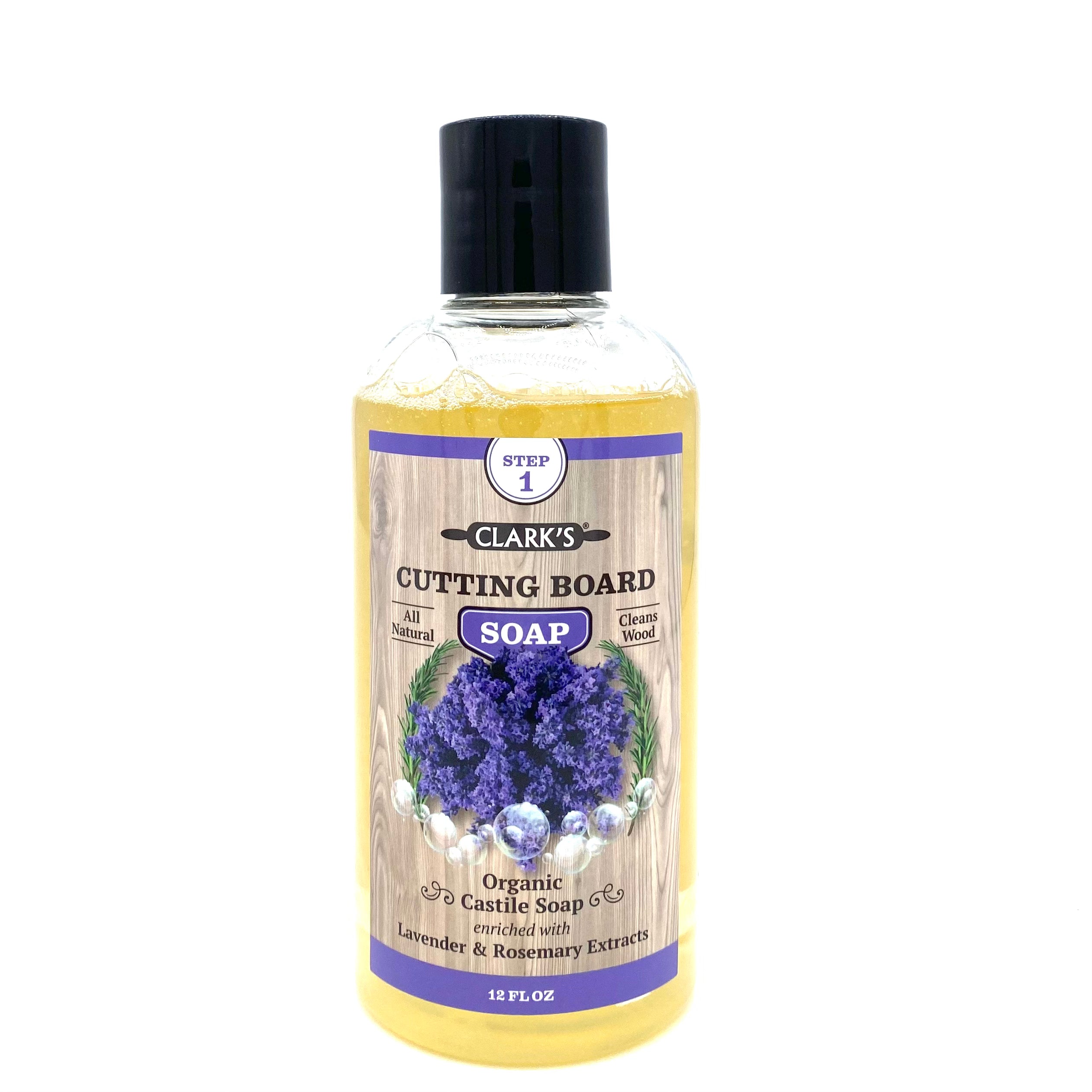 Clear plastic bottle with black lid. Soap is pale yellow, image on label features wood background and lavender bunches. 