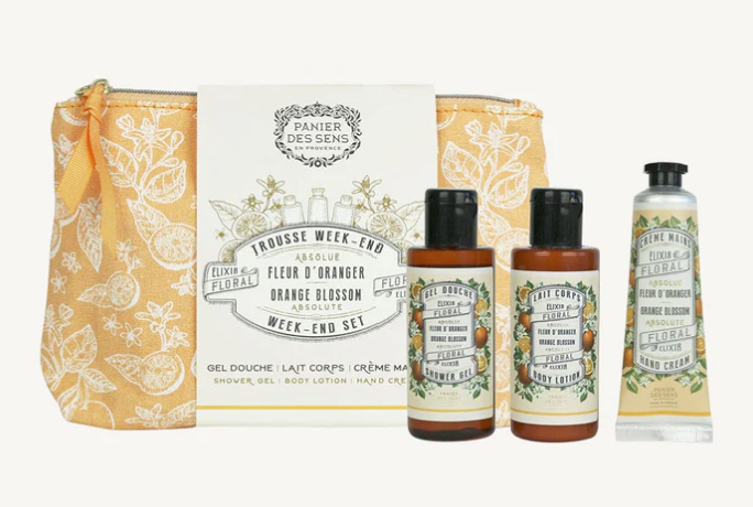 Panier Des Sens week-end set.  Three products in an orange colored bag with white floral and orange pattern.  The Shower Gel and Body Lotion are in brown bottles with black Lid, hand cream in orange tube with black lid.  The label have images of blossoms and oranges.