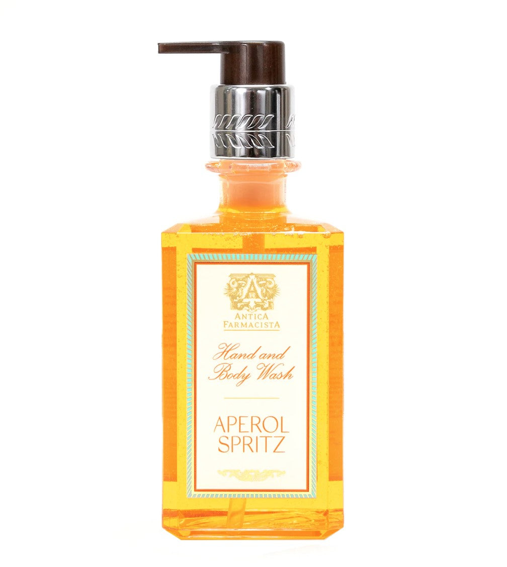 Image of hand soap in clear plastic bottle with black pump lid, soap is orange in color. White label with orange writing stating "Hand wash and body wash Aperol Spritz"