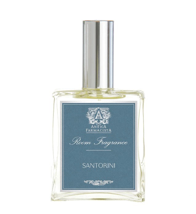 Image of clear glass bottle with silver cap, with blue label and white writing stating "Room Fragrance Aperol Santorini"